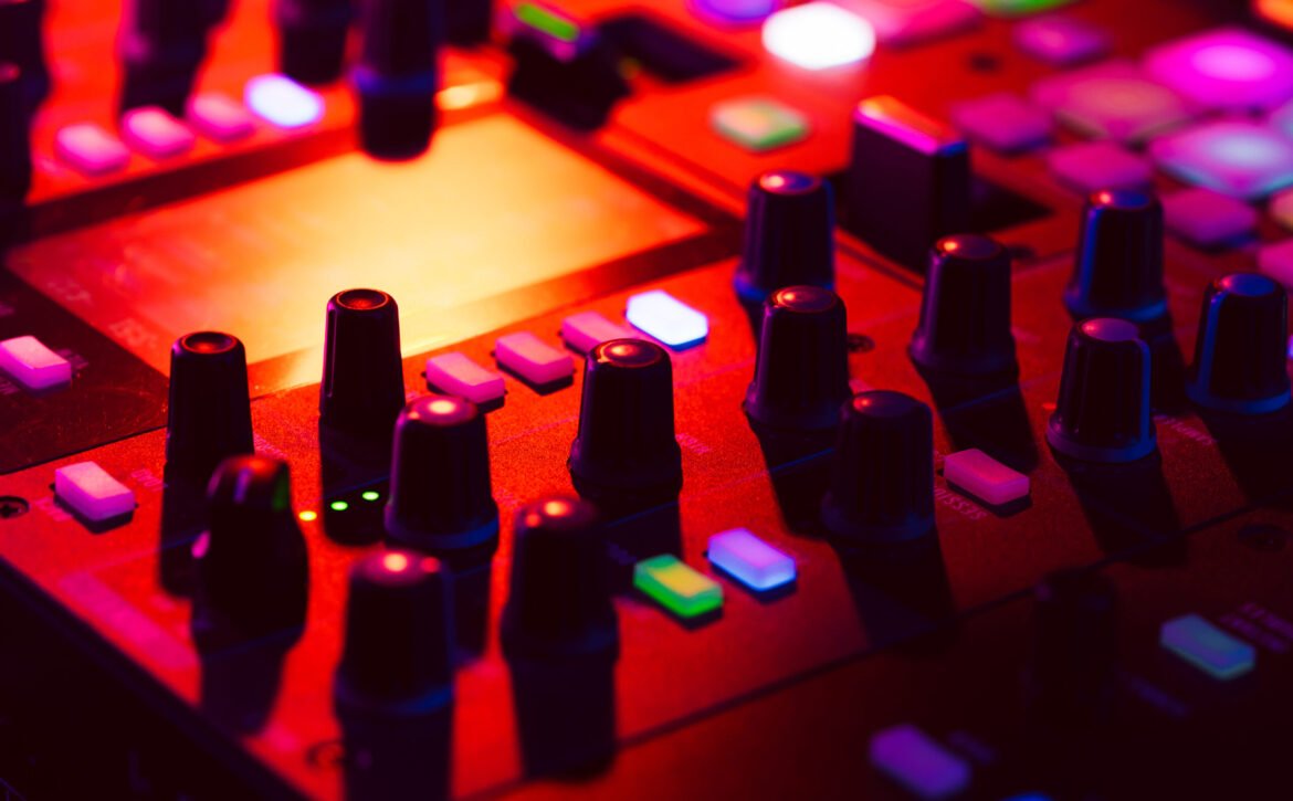 Close up of DJ mixing console in party light