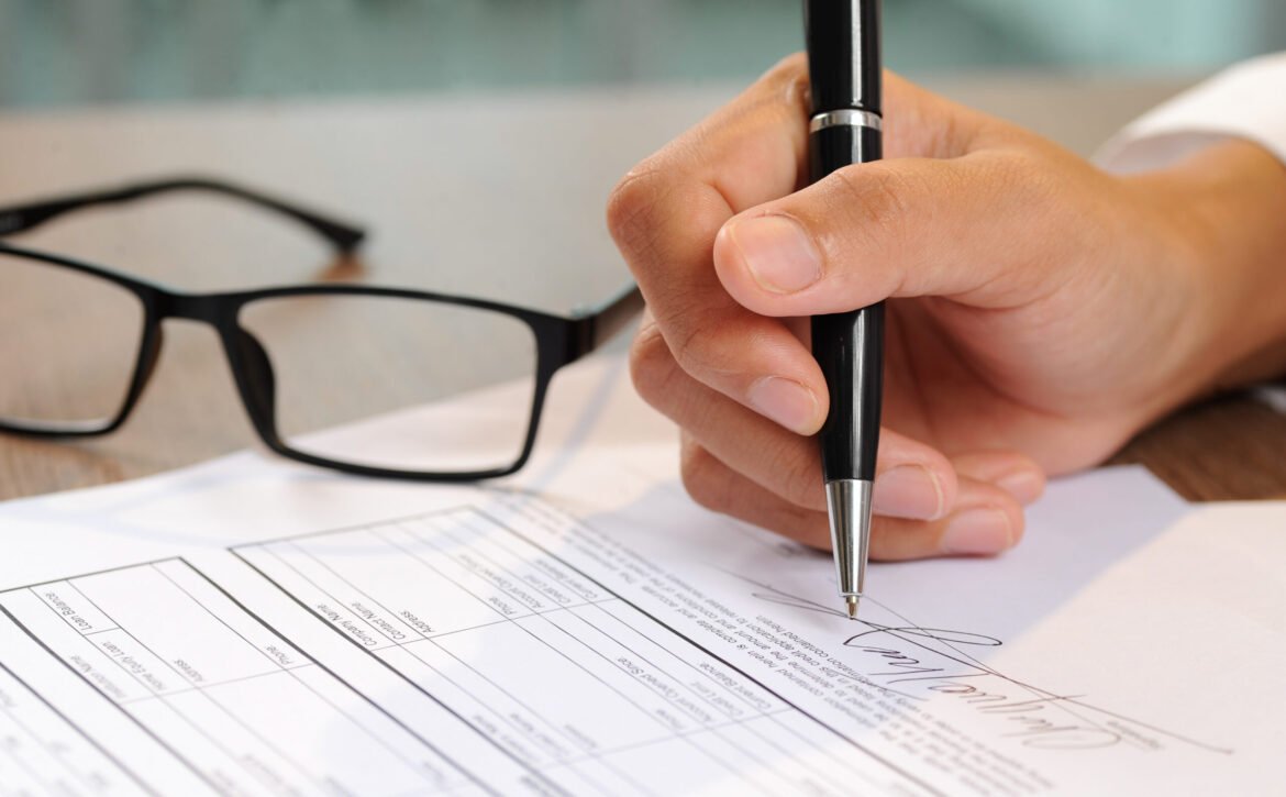 Closeup of woman signing document