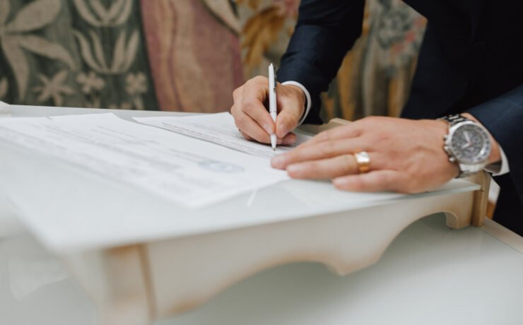 Man with a pen signs a document